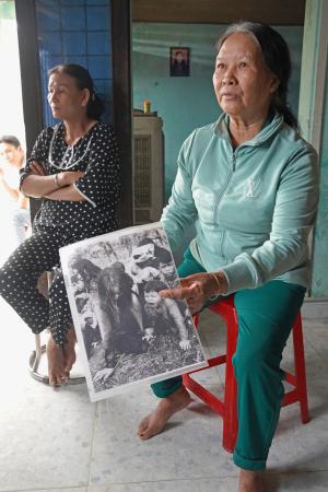 　渡河後の写真を見せるグエン・ティ・キム・リエンさん＝２０２５年３月、ベトナム・ビンディン省ロクチュアン村（共同）