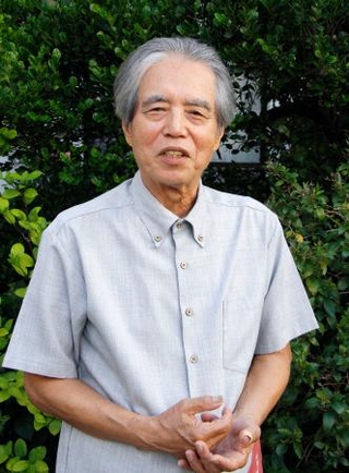 　自宅の庭でインタビューに答える新城俊昭さん