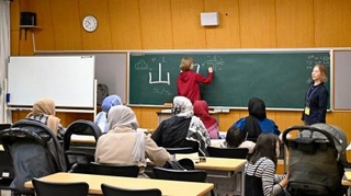　子どもをあやしながら日本語を学ぶアフガン女性たち＝５月、千葉市