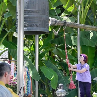 　栃木県さくら市の東輪寺にある「平和の鐘」を突く小松宏生さん＝２０２４年８月