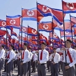 　朝鮮人民軍の前身とされる朝鮮人民革命軍の創建９３年を記念し、北朝鮮の国旗を掲げる人たち＝４月、平壌