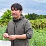 　ハーブリキュールの原料となるハーブを育てる畑に立つ老川和磨さん＝岩手県金ケ崎町