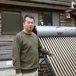 　「現代集落」のプロジェクトの拠点となる古民家で、太陽熱温水器の説明をする林俊伍さん＝２０２５年６月３日、石川県珠洲市