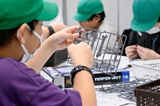 　「静岡ホビーショー」でプラモデル作りを体験する児童＝５月、静岡市