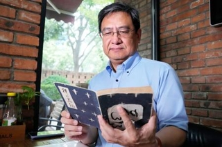 　太平洋戦争末期に中国で出版された壺井栄の短編集「絣の着物」を手にする北京外国語大の秦剛教授＝７月、北京（共同）