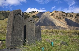 　足尾銅山の煙害で廃村となった旧松木村跡に残る墓石。後方は鉱滓（こうさい）の山＝２０１７年８月、栃木県日光市
