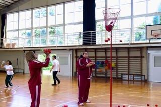 　廃校を活用して外国人に日本の学校生活を体験してもらうイベント「君ノ高校」で、運動会の玉入れをする参加者ら＝２０２５年７月、千葉県君津市