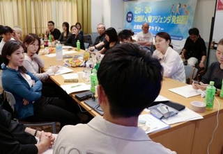 　日本人学生らに生い立ちを語る脱北者の男性（手前）＝６月、大阪市生野区