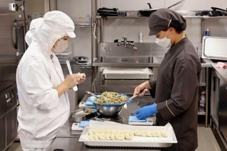 　「ＦＬＡＴ　ＨＡＣＨＩＲＯＫＵ」でギョーザを作るスタッフ＝２０２５年８月、名古屋市