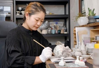 　絵付け作業をする九谷焼作家の松村沙世さん＝２０２５年８月１４日、石川県加賀市