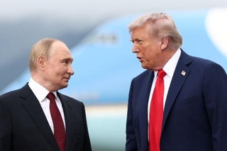 　会談のため米アラスカ州アンカレジのエルメンドルフ・リチャードソン米軍基地に到着し、言葉を交わすロシアのプーチン大統領（左）とトランプ大統領＝８月１５日（ロイター＝共同）