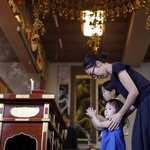 　福岡大空襲の慰霊法要で手を合わせる親子＝６月１５日午後、福岡市