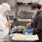 　「ＦＬＡＴ　ＨＡＣＨＩＲＯＫＵ」でギョーザを作るスタッフ＝２０２５年８月、名古屋市