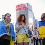 　東京・渋谷で開かれた在日ウクライナ人らによる集会で、ロシアによる軍事侵攻の犠牲者に黙とうをささげる人たち＝２４日午後