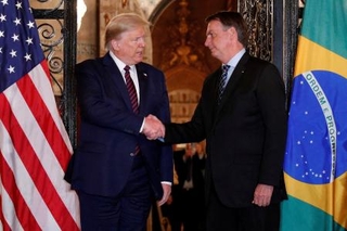 　トランプ米大統領（左）と握手を交わすブラジルのボルソナロ前大統領＝２０２０年３月、米フロリダ州パームビーチ（ロイター＝共同）