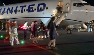 　関西空港に緊急着陸した米ユナイテッド航空機から、脱出用シューターを使って避難する乗客＝１２日（乗客提供）