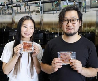　アルコールフリーのたれを使ったウナギのかば焼きを手にする鯉平の営業事務課長松井洋一さん（右）ら＝８月、さいたま市