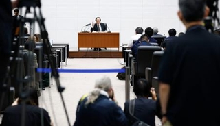 　金融政策決定会合後、記者会見する日銀の植田総裁（奥）＝１９日午後、日銀本店