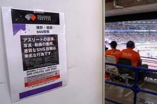 　観客席近くに掲示された、アスリートの写真や動画の悪用などに注意を呼びかける張り紙＝１８日、東京・国立競技場