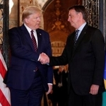 　トランプ米大統領（左）と握手を交わすブラジルのボルソナロ前大統領＝２０２０年３月、米フロリダ州パームビーチ（ロイター＝共同）