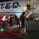 　関西空港に緊急着陸した米ユナイテッド航空機から、脱出用シューターを使って避難する乗客＝１２日（乗客提供）