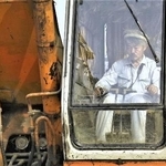 映画「荒野に希望の灯をともす」の一場面。用水路建設のためショベルカーで作業する中村哲さん（日本電波ニュース社提供）