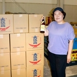 　松波酒造の日本酒を手にする金七聖子さん＝２０２５年８月、石川県小松市
