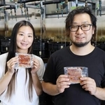 　アルコールフリーのたれを使ったウナギのかば焼きを手にする鯉平の営業事務課長松井洋一さん（右）ら＝８月、さいたま市