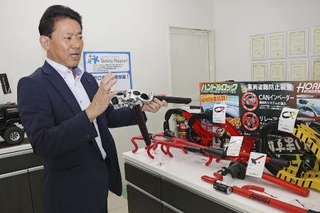 　カーセキュリティー機器について説明する加藤電機の加藤学社長＝７月、名古屋市