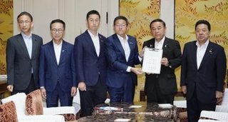 　ガソリン税の暫定税率廃止法案の提出に向け、署名した合意文書を手にする与野党の国対委員長ら＝７月、国会