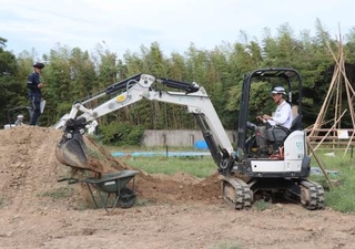 　重機で土砂を運搬する操作方法を確認する参加者＝９月、千葉県木更津市