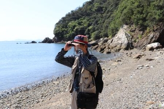 ニホンカワウソがいそうな場所を双眼鏡で調べる千葉昇さん＝１０月、愛媛県西予市