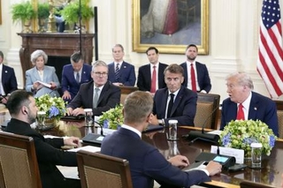 　米ホワイトハウスで行われたウクライナのゼレンスキー大統領（手前左）や欧州首脳との拡大会合で話すトランプ大統領（奥右）。奥左からは英国のスターマー首相、フランスのマクロン大統領＝８月１８日（ＡＰ＝共同）