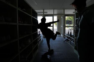 　ヘルパーの付き添いで大阪府豊中市の小学校に通学し、玄関でおどける児童＝９月