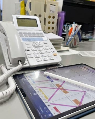 　保護者に連絡する際に使用した事務室の固定電話。保護者とのやりとりを、その都度タブレット端末に記録している（画像の一部に加工をしています）