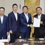 　ガソリン税の暫定税率廃止法案の提出に向け、署名した合意文書を手にする与野党の国対委員長ら＝７月、国会