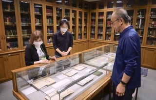 　小泉八雲の蔵書を集めた「ヘルン文庫」の展示を見る村上弘美さん（左）と木下晶さん（右）ら＝２０２５年１０月１５日、富山市