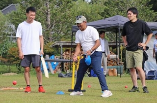 　クリケットの体験会で参加者を指導するビネイ・クマールさん（中央）＝９月、浜松市