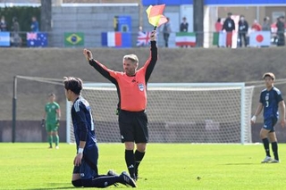 　サッカー男子の日本-オーストラリア戦で、笛だけでなく、旗も使うサッカーの主審＝福島県Ｊヴィレッジ