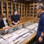 　小泉八雲の蔵書を集めた「ヘルン文庫」の展示を見る村上弘美さん（左）と木下晶さん（右）ら＝２０２５年１０月１５日、富山市