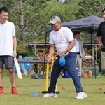 　クリケットの体験会で参加者を指導するビネイ・クマールさん（中央）＝９月、浜松市