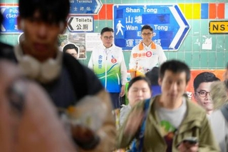 　火災が発生した選挙区で選挙活動を再開したトウ肇峰候補（奥右）＝５日、香港（共同）