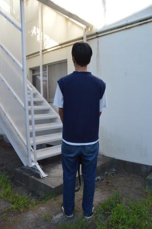 　かつて育った児童養護施設の建物を見つめる佐藤さん（仮名）＝７月