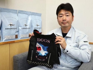 　犬用のライダースジャケット「サメジャン」と総合栄養食を紹介する石渡商店の石渡久師代表取締役＝宮城県気仙沼市