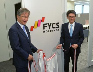 　ＦＩＣＳ発足式で記念写真に納まる会長の丸山公夫さん（左）と社長の石沢顕さん。ロゴのリボンは４局と日本列島を表現している＝２０２５年４月１日、東京・汐留