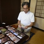 妻泰子さんの写真を見つめる荒川勉さん＝２０２４年９月、鳥取県米子市