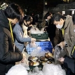 　屋外で弁当など食料品の配布準備をするＮＰＯ法人「ＴＥＮＯＨＡＳＩ」の関係者ら＝１３日、東京・池袋