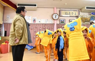 　「みなと保育園」の避難訓練で、園児に語りかける和田信寿園長（左）＝２０２５年１２月、福島県相馬市