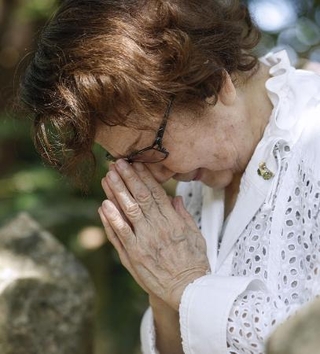 沖縄県糸満市にある戦没した医療従事者の碑に手を合わせる玉木利枝子さん＝２０２５年６月２２日