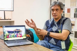 　「赤い家」の再建に必要な改修箇所を解説するジョエル・リコさん＝２０２５年１２月、マニラ（共同）